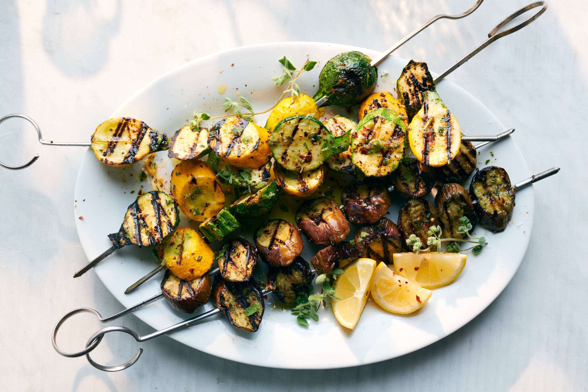 An overhead image of grilled squash slices threaded onto skewers.