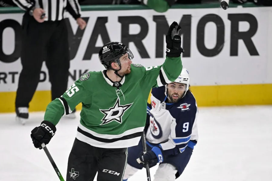 May 17, 2025; Dallas, Texas, USA; Dallas Stars defenseman Thomas Harley (55) catches the puck in the air as Winnipeg Jets left wing Alex Iafallo (9) looks on during the second period in game six of the second round of the 2025 Stanley Cup Playoffs at American Airlines Center. Mandatory Credit: Jerome Miron-Imagn Images
