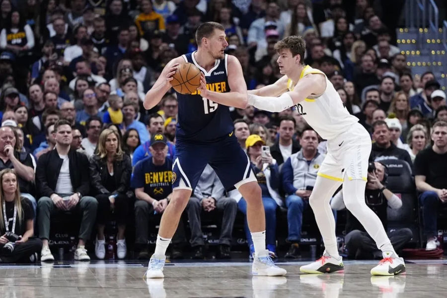 Mar 28, 2025; Denver, Colorado, USA; Utah Jazz forward Kyle Filipowski (22) defends on Denver Nuggets center Nikola Jokic (15) in the second quarter at Ball Arena. Mandatory Credit: Ron Chenoy-Imagn Images