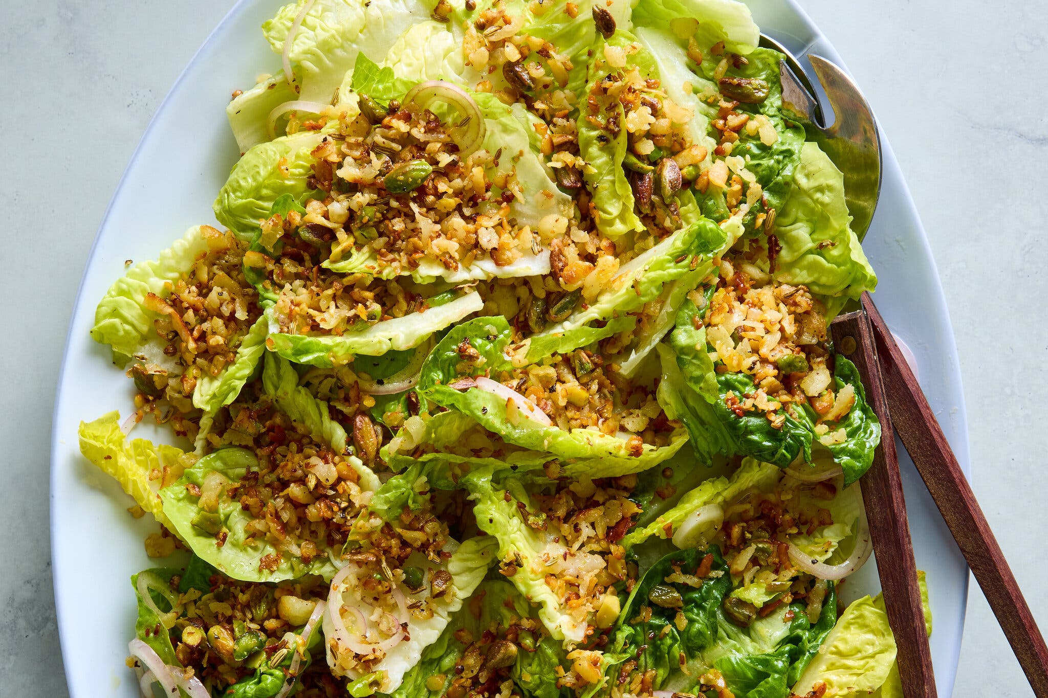 Crumbled halloumi sits on a bed of lettuce leaves.