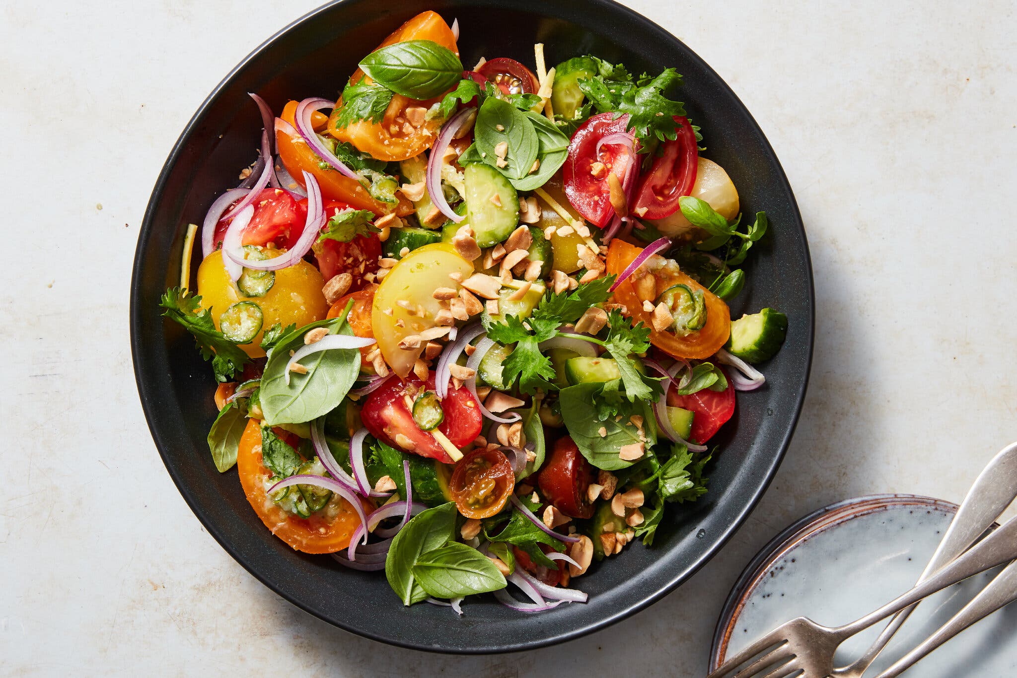 An overhead image of a cucumber-tomato-basil salad. 