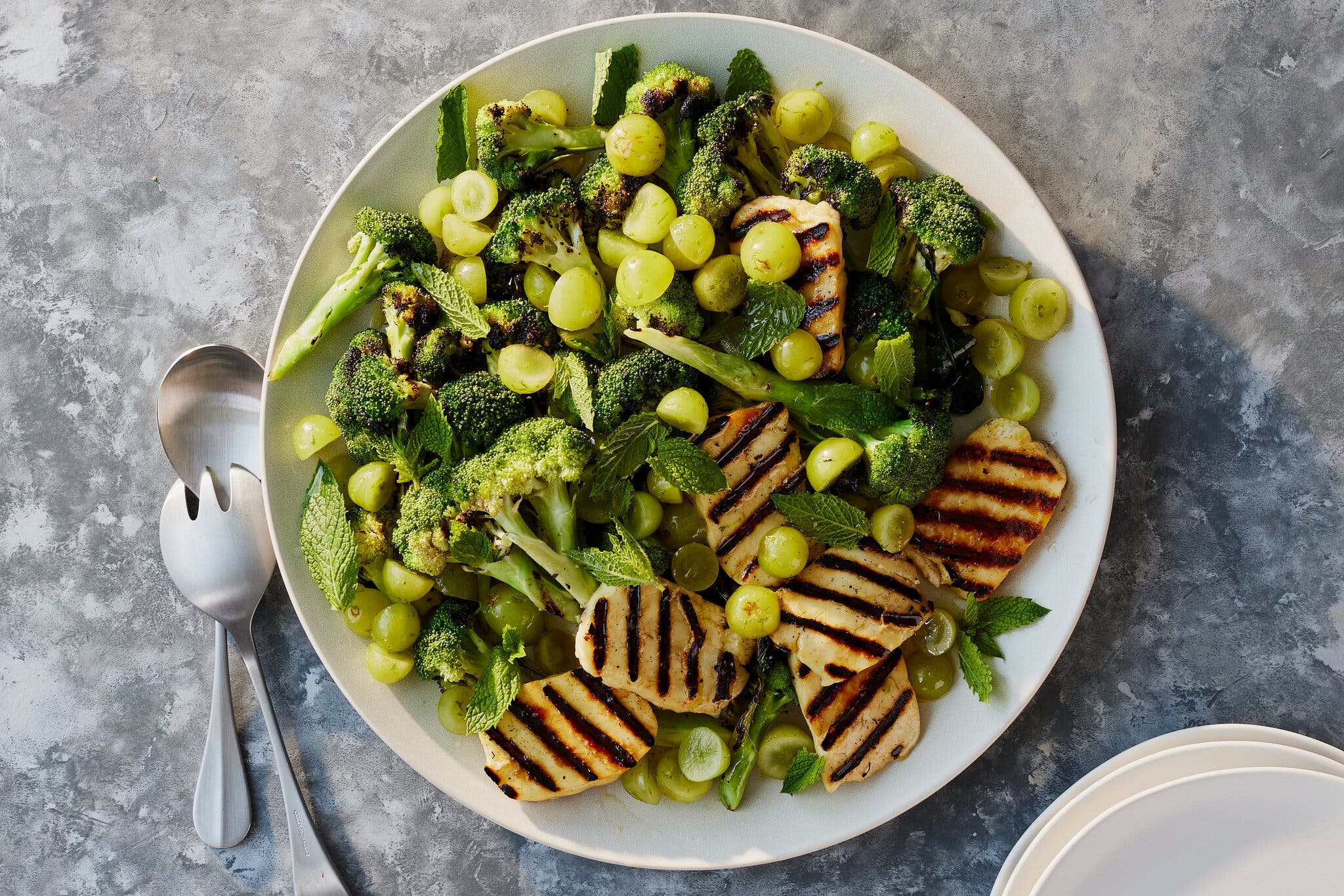 An overhead image of grilled halloumi, grapes and broccoli.