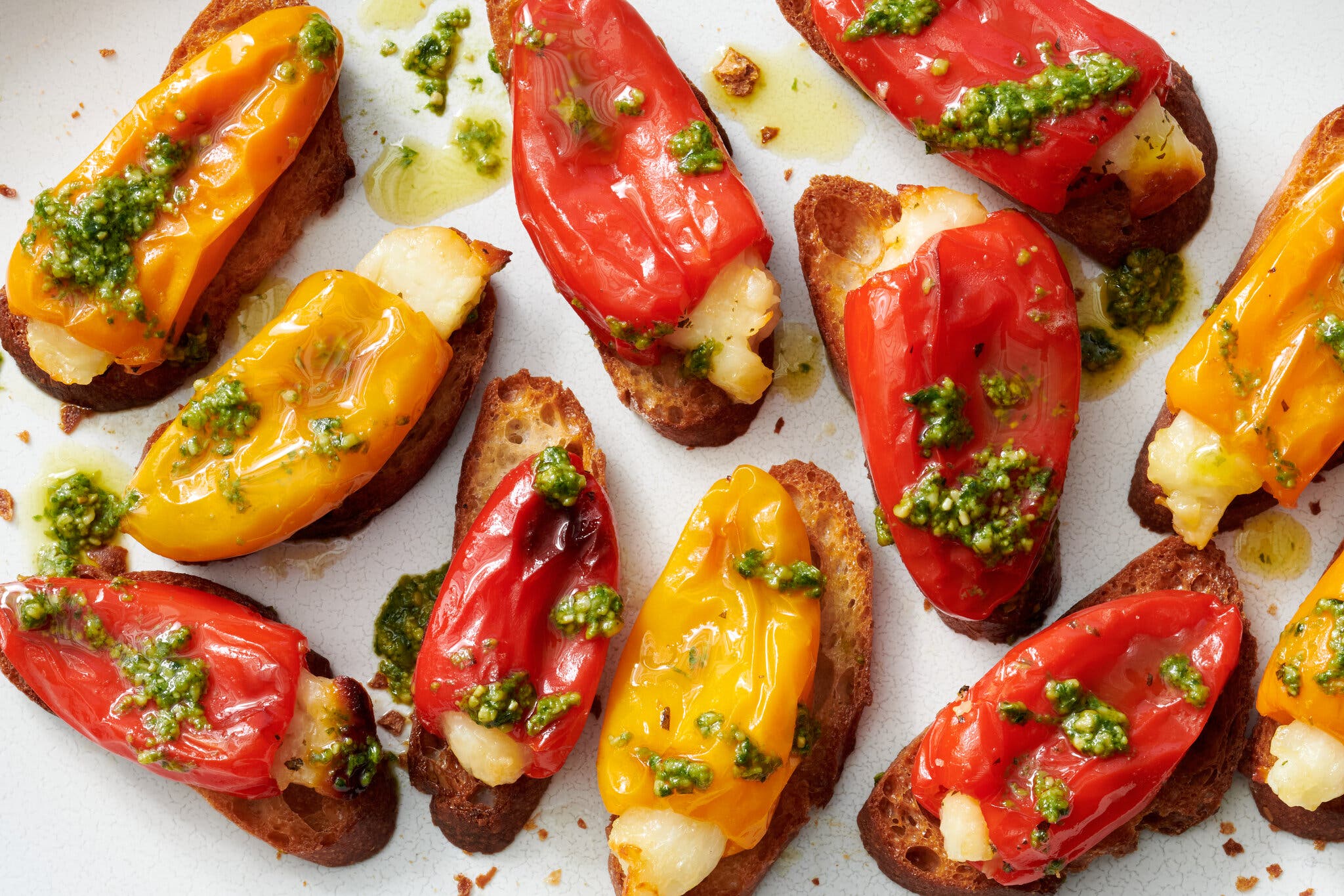 An overhead image of small cheese-filled peppers on crostini.
