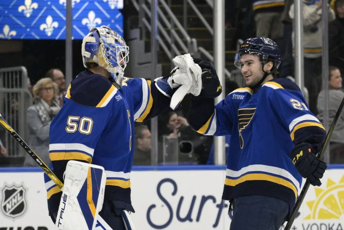 Apr 15, 2025; St. Louis, Missouri, USA; St. Louis Blues right wing Jimmy Snuggerud (21) and goaltender Jordan Binnington (50) celebrate a win against the Utah Hockey Club at Enterprise Center to clinch a spot in the playoffs. Mandatory Credit: Jeff Le-Imagn Images