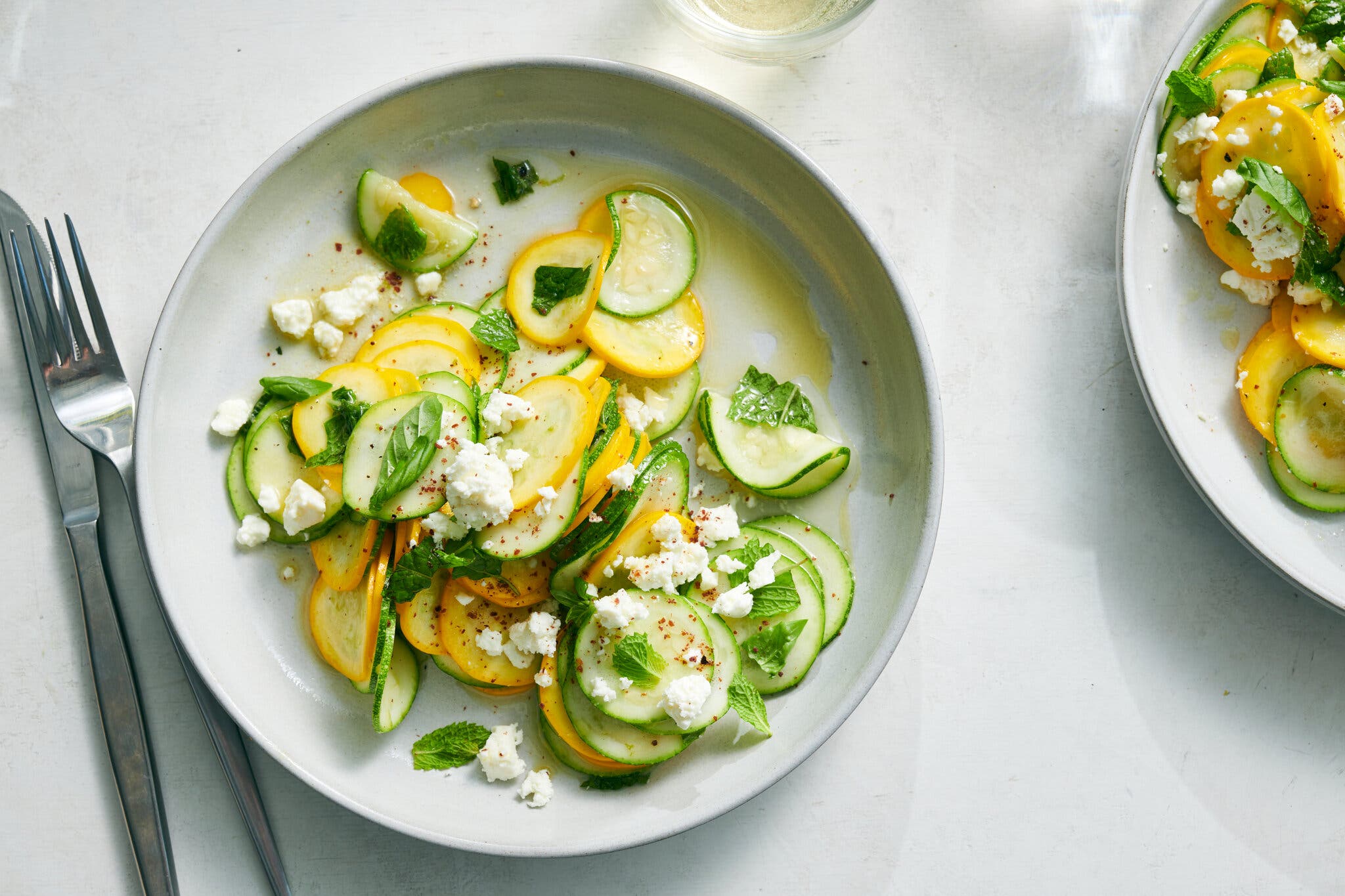 A plate shaved zucchini salad with basil, mint and feta. 