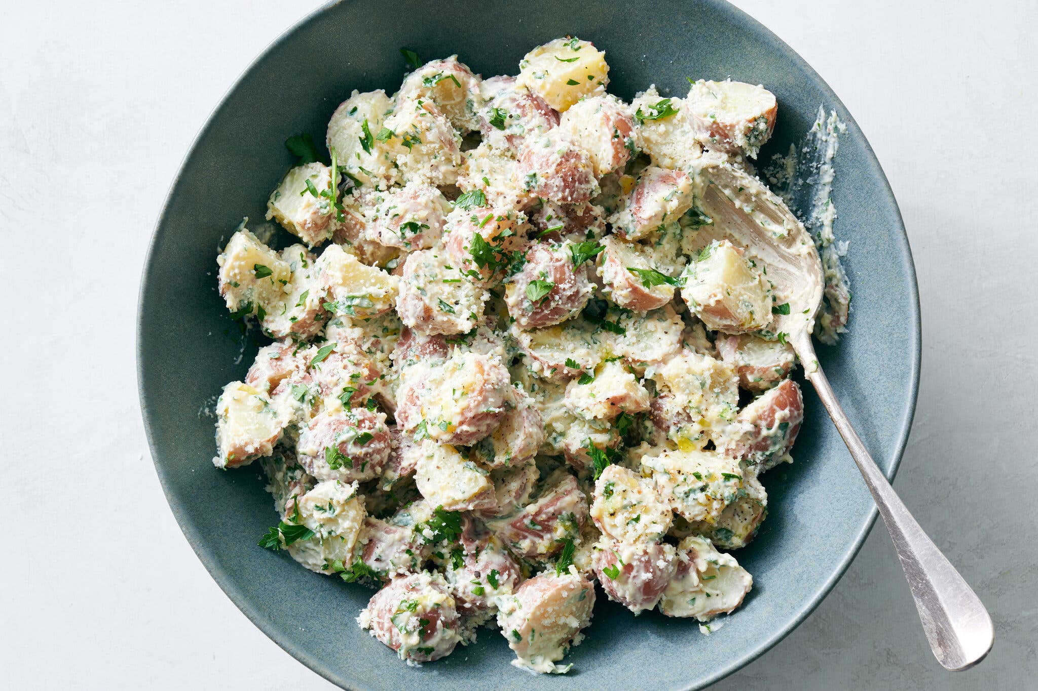 Caesar potato salad in a blue bowl. 