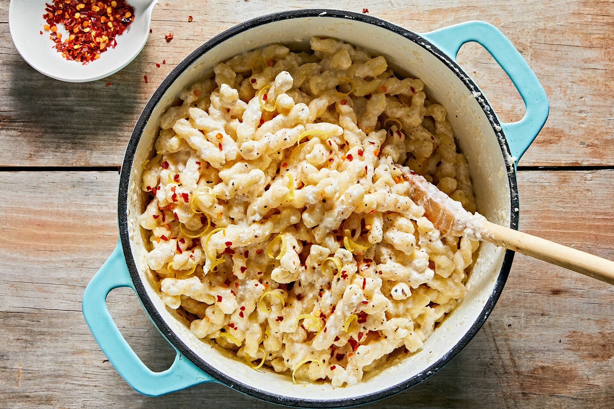 An overhead image of a Dutch oven filled with creamy noodles.