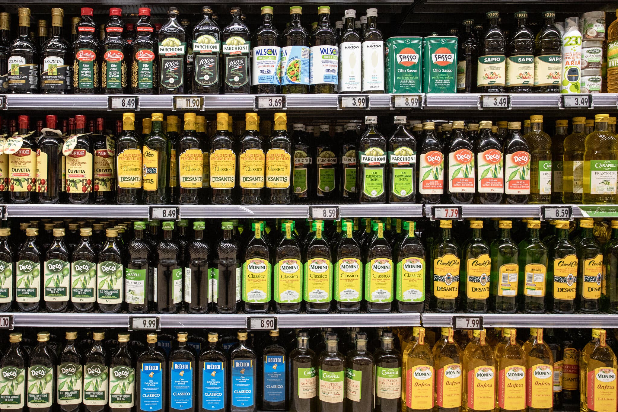 Rows of olive oil on grocery store shelves.
