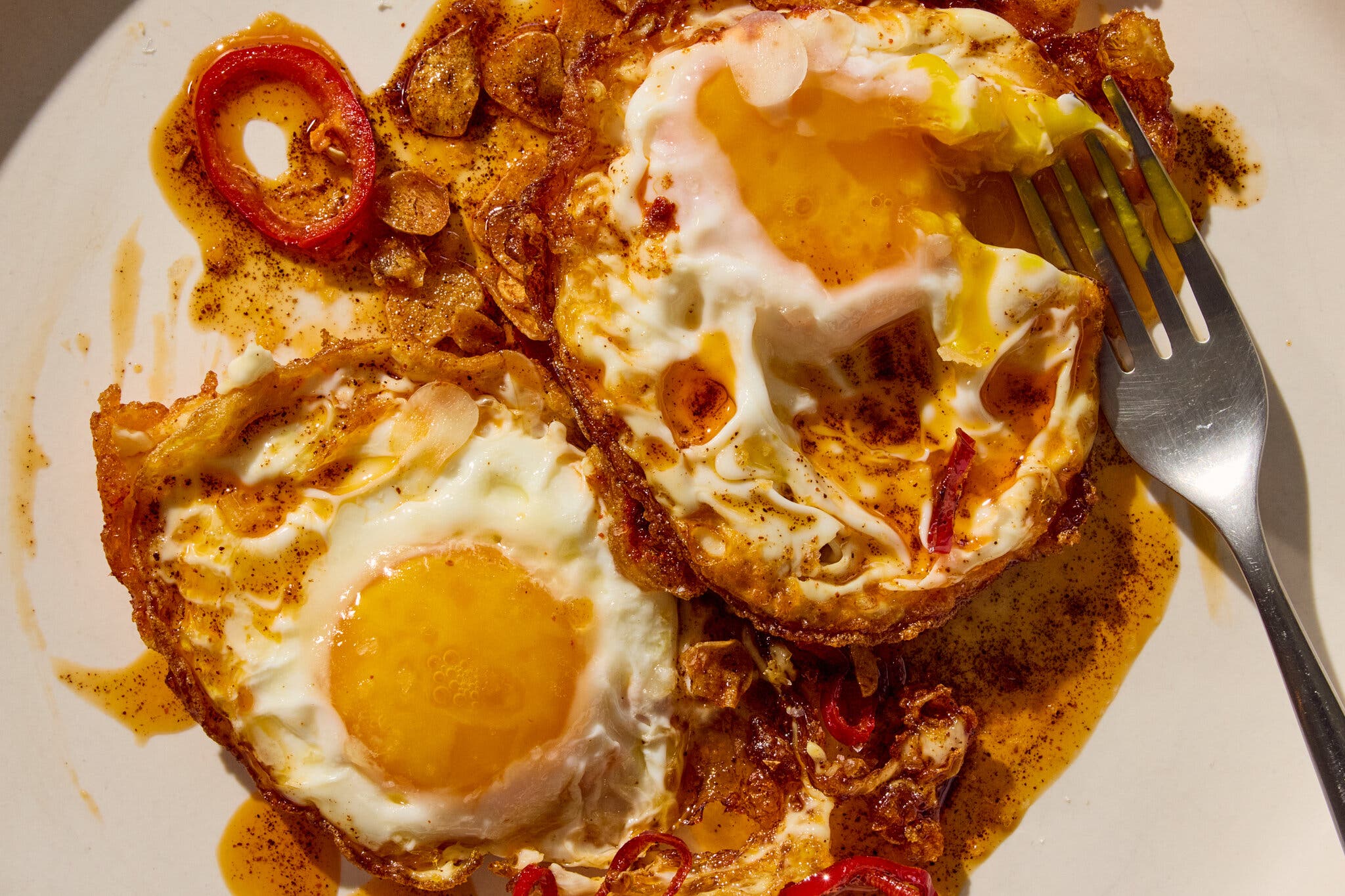 An overhead image of eggs in a red spiced sauce.