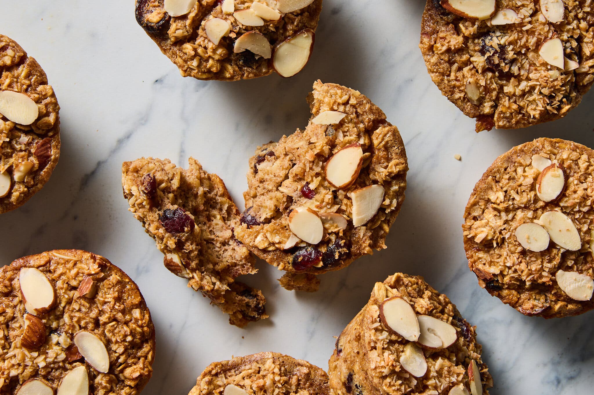 An overhead image of oatmeal muffins topped with sliced almonds.