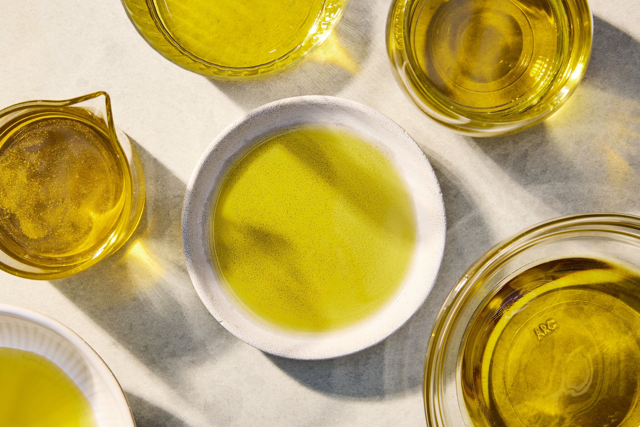 An overhead image of various jars filled with olive oil.
