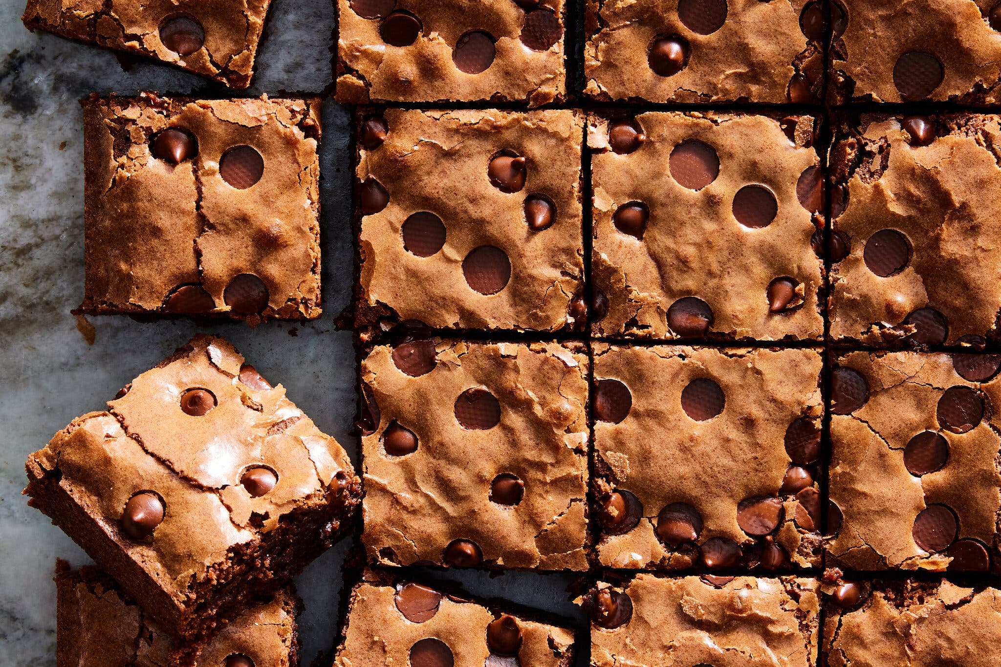 An overhead image of mochi brownies cut into squares and studded with chocolate chips.