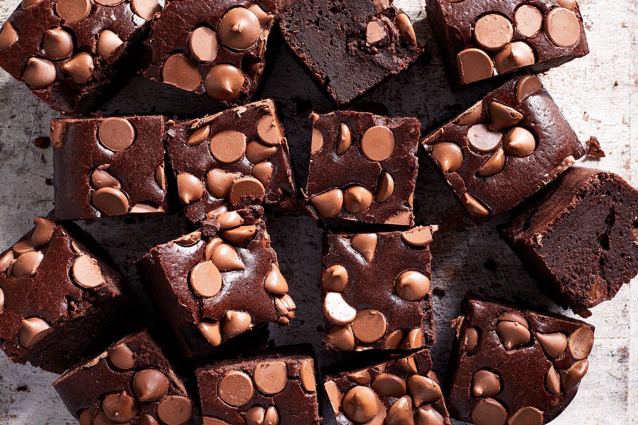 An overhead image of Guinness brownies, cut into small squares, studded with milk chocolate chips.
