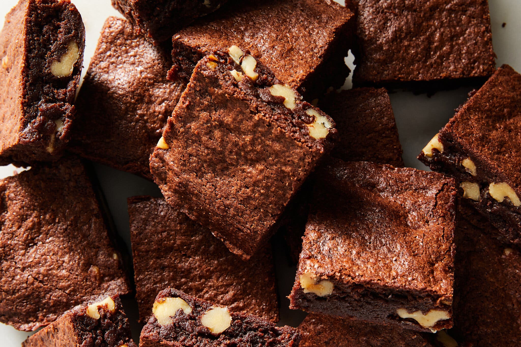 A close up, overhead image of brownies with chopped walnuts.