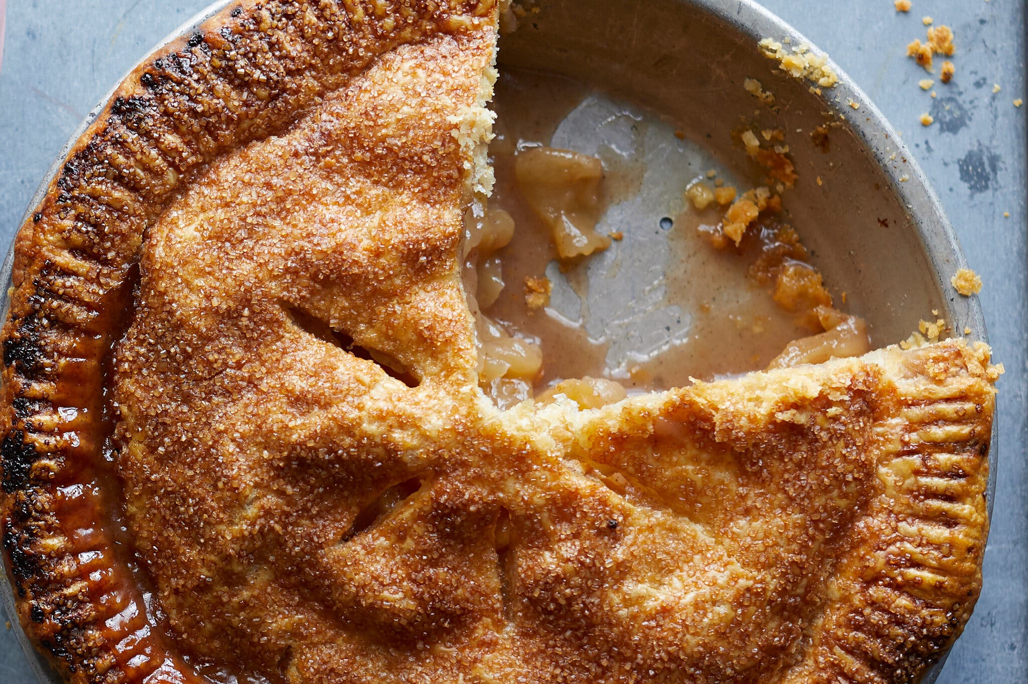 An overhead image of a baked apple pie with a slice taken out.