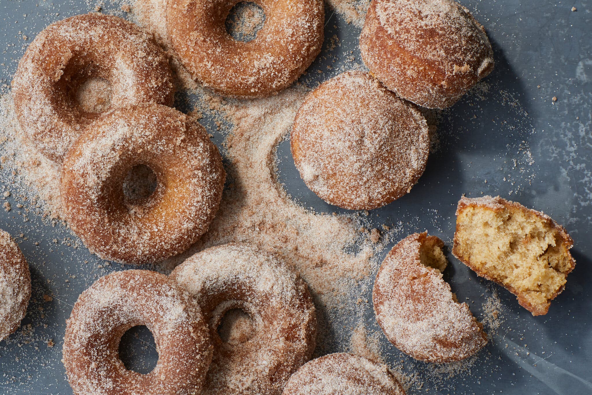 An overhead image of cinnamon sugar dusted apple doughnuts.