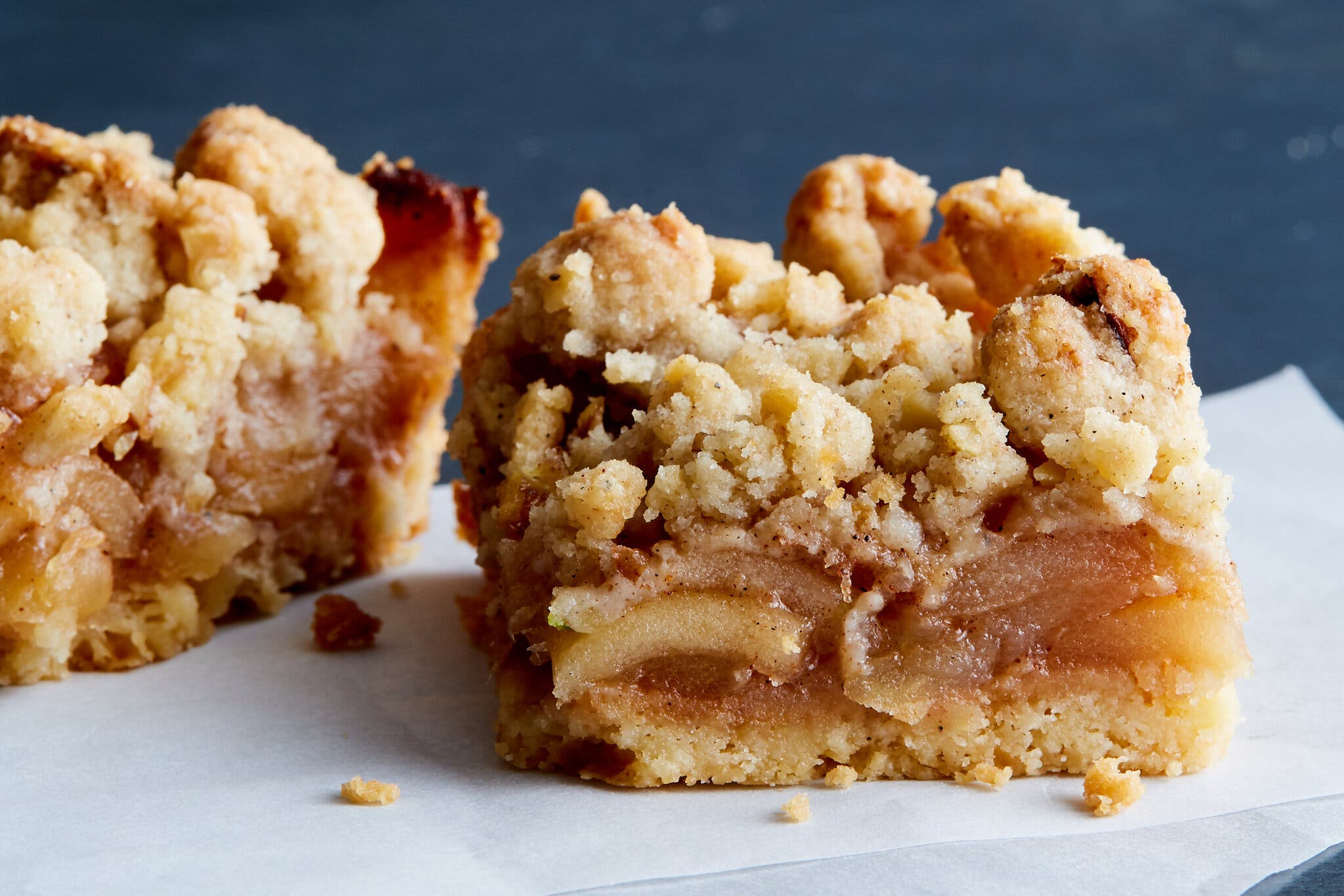 A side image of apple bars topped with a crumble.