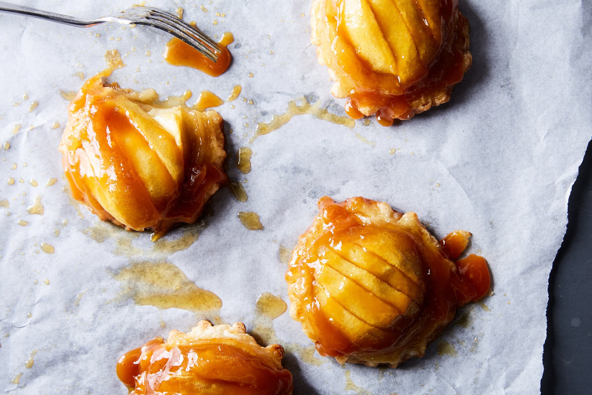 An overhead image of mini tartes tatin on a piece of parchment.