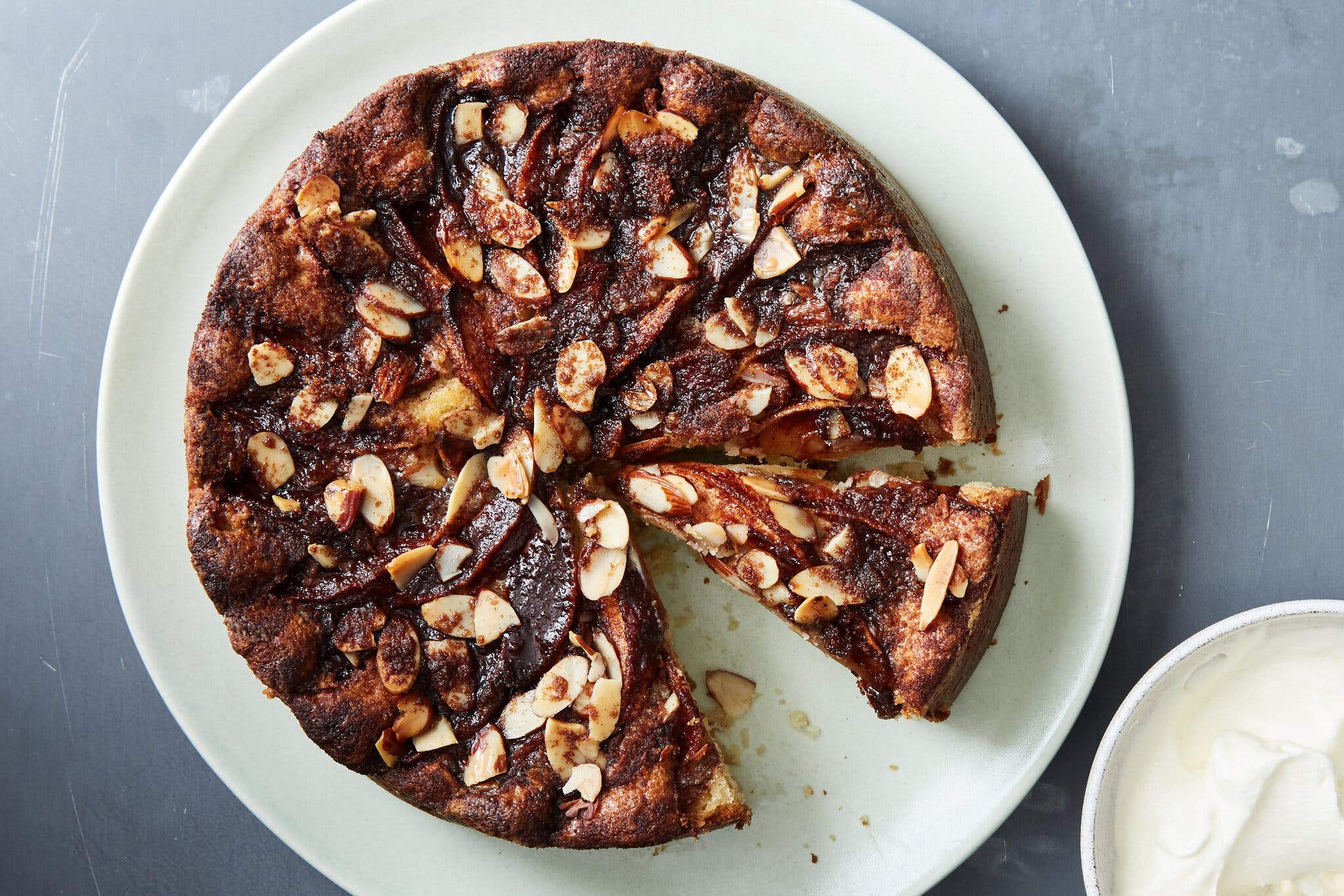 An overhead image of a jammy cake topped with sliced almonds.