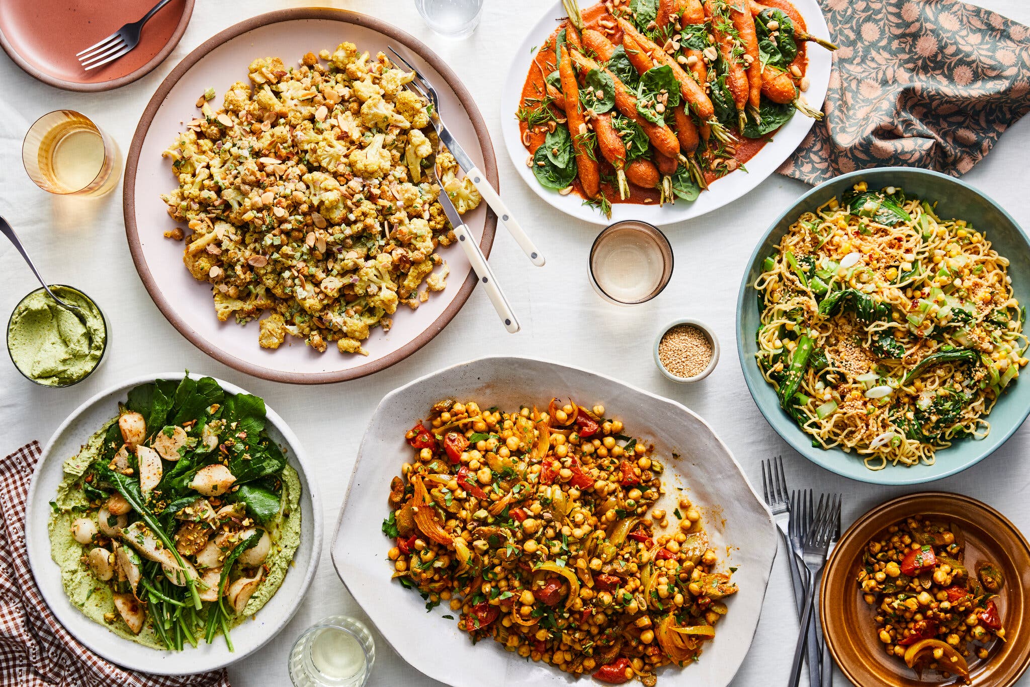An overhead image of table set with various salad platters, piled high with vegetables.