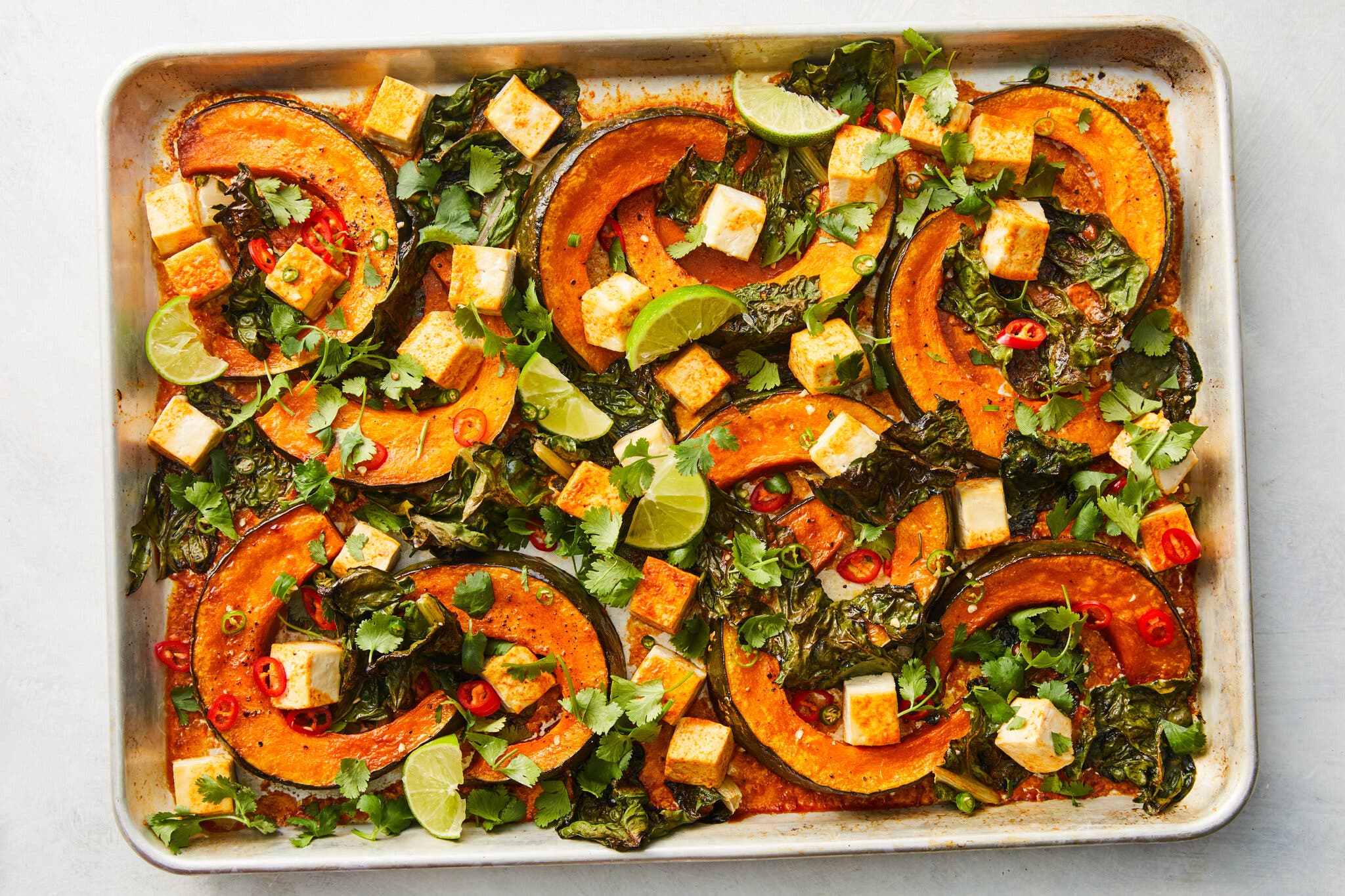 An overhead image of halved squash rings topped with tofu and herbs.
