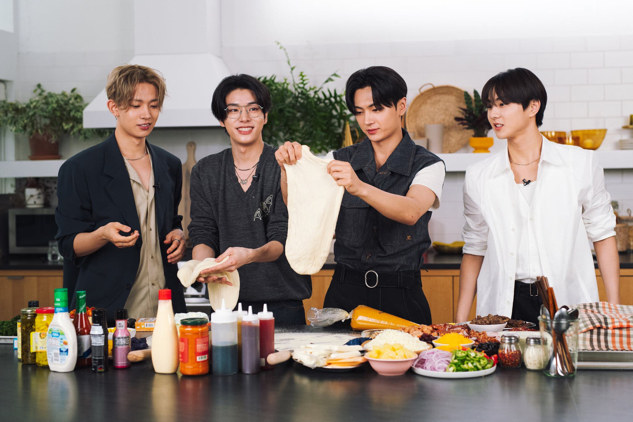 Four well-dressed singers make pizzas in the New York Times kitchen studio.
