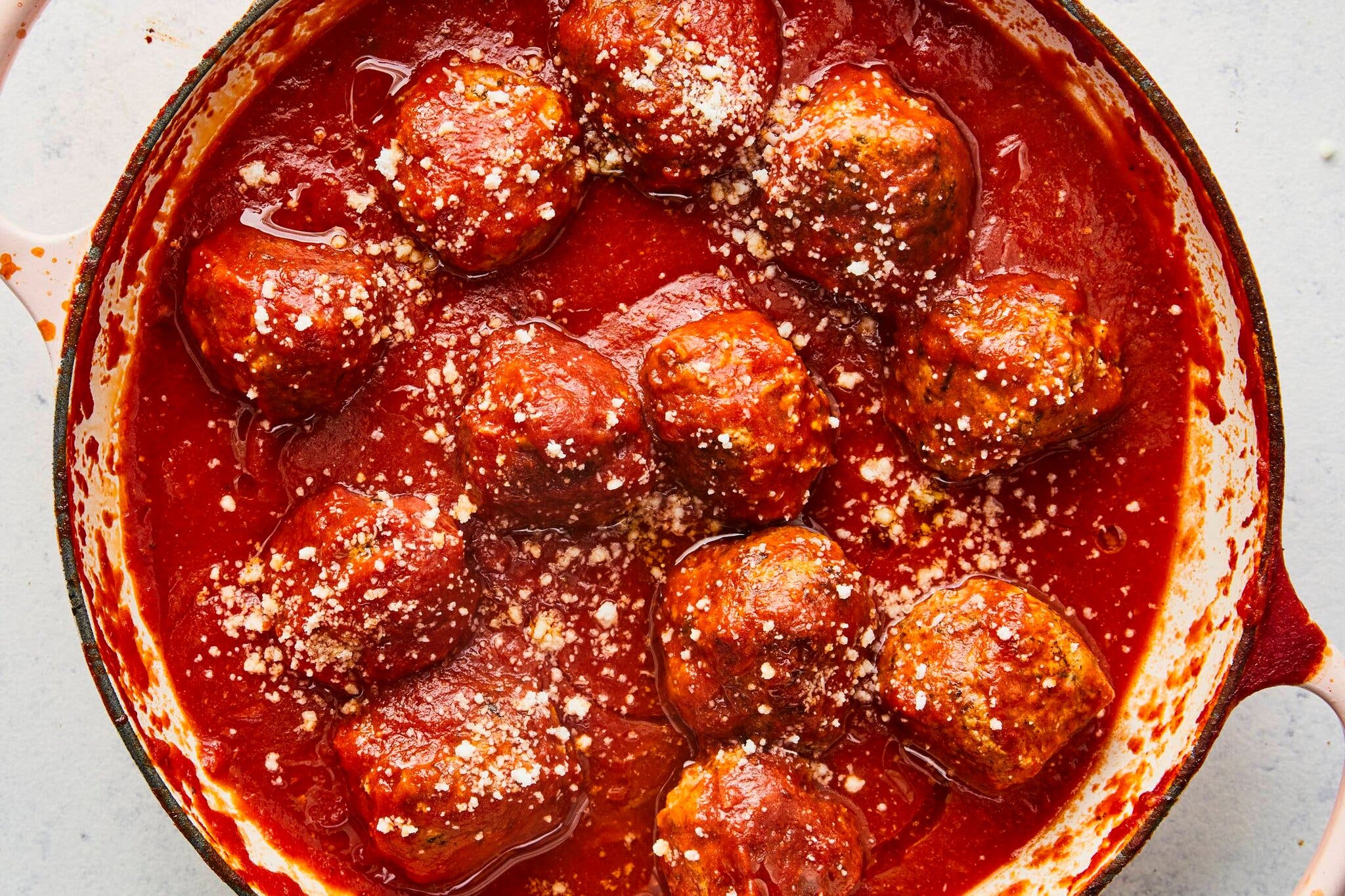 A short video showing a meatball being shaped with a spoon.