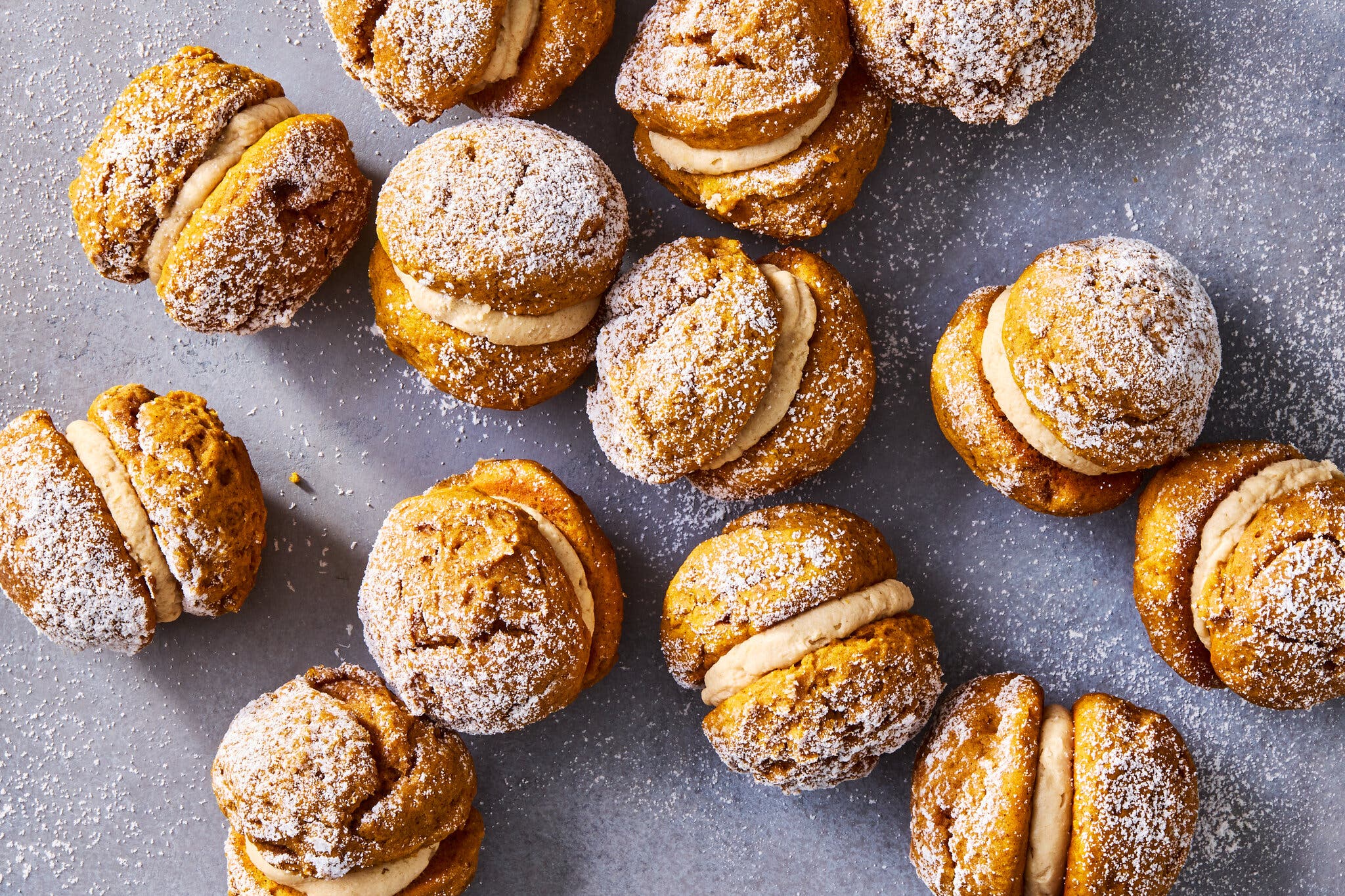 An overhead image of mini pumpkin spice whoopie pies dusted with powdered sugar. 
