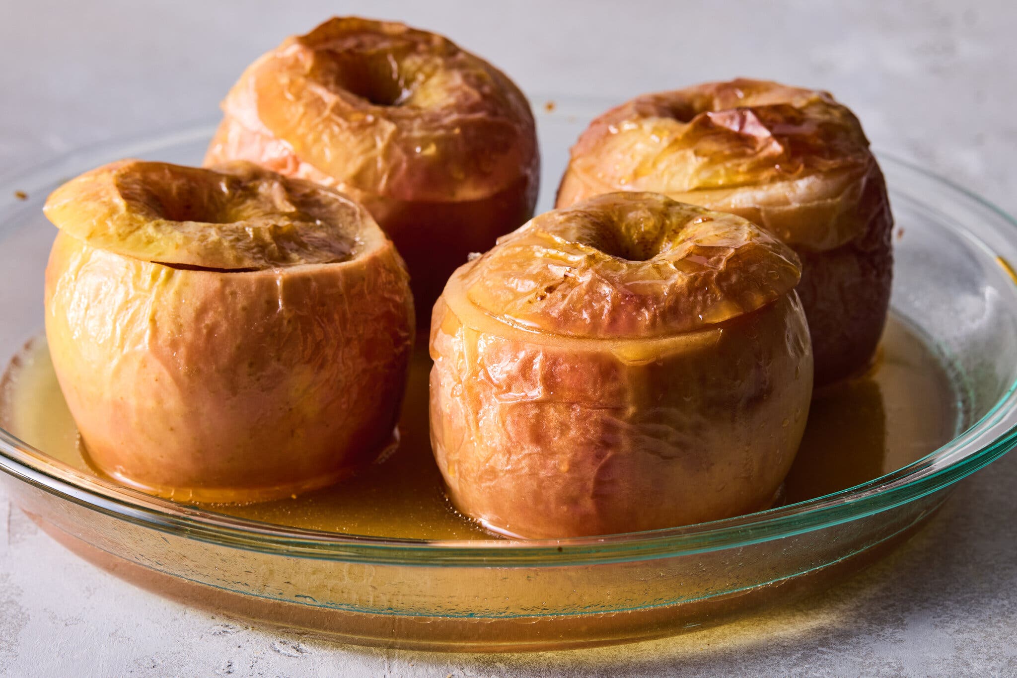 A glass bowl of baked apples.