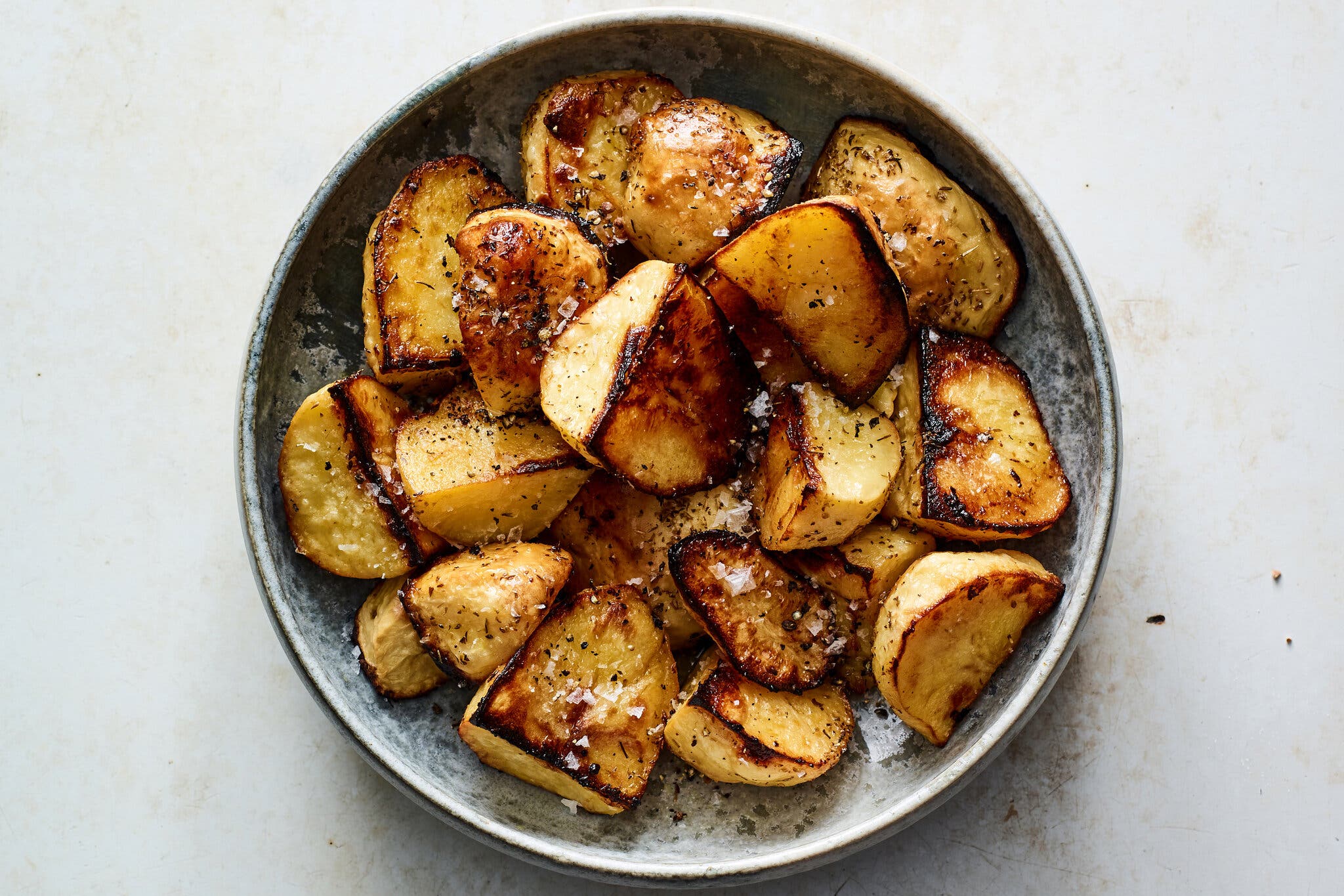 An overhead image of roasted potatoes in a bowl.