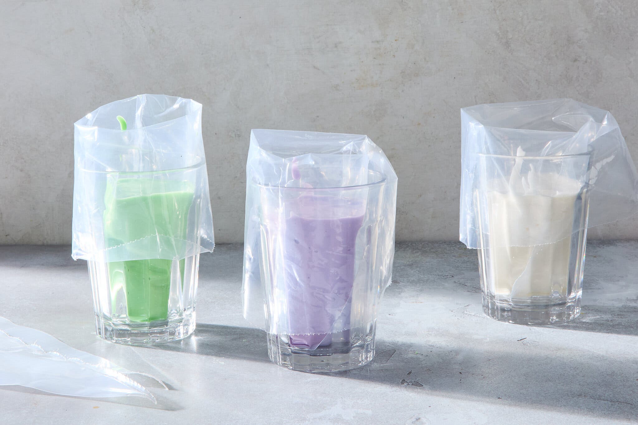 A side image of three glasses holding icing-filled piping bags.