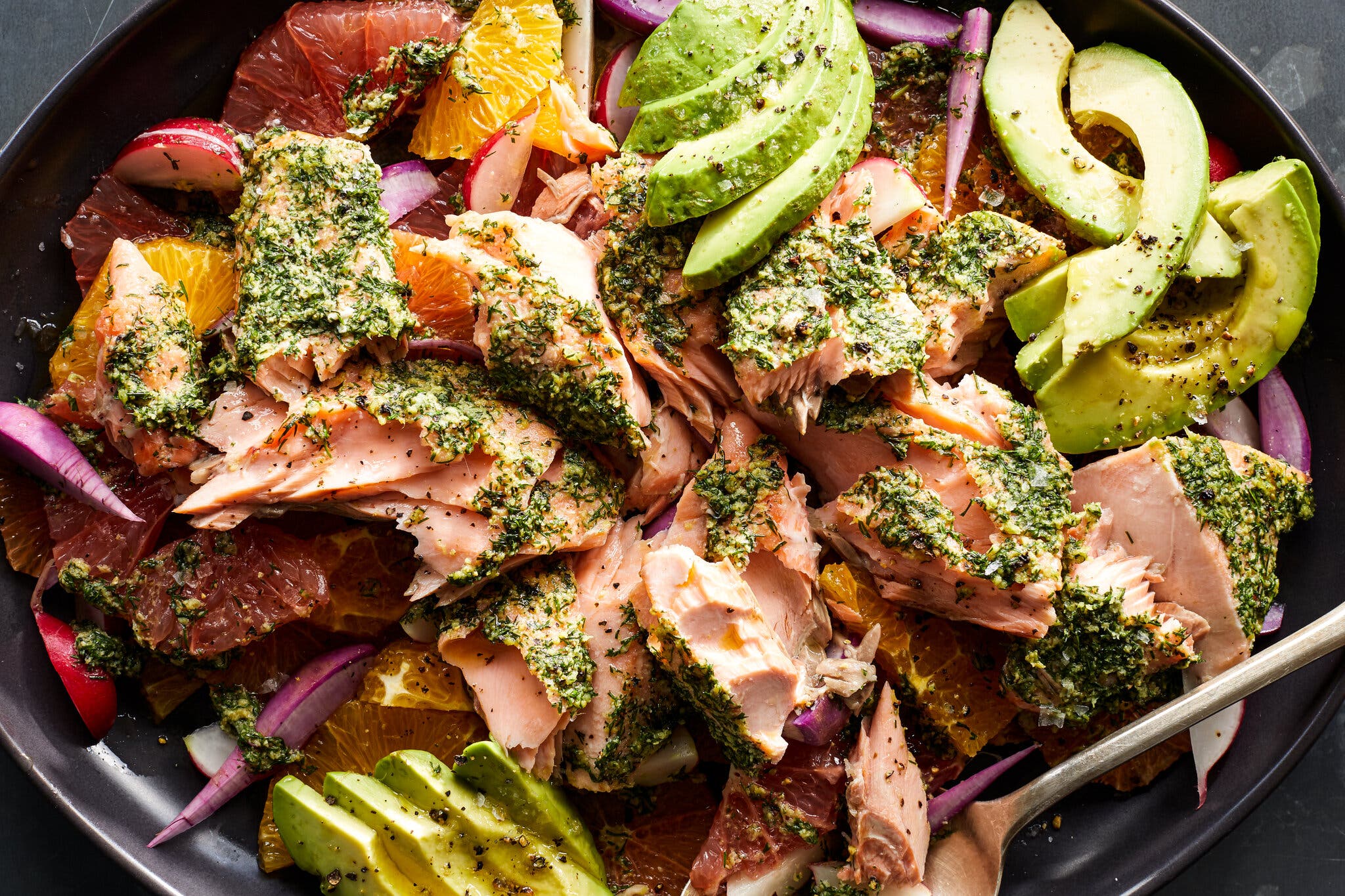 Flaked herb-crusted salmon served over a vibrant salad of grapefruit, orange slices, radish and avocado.