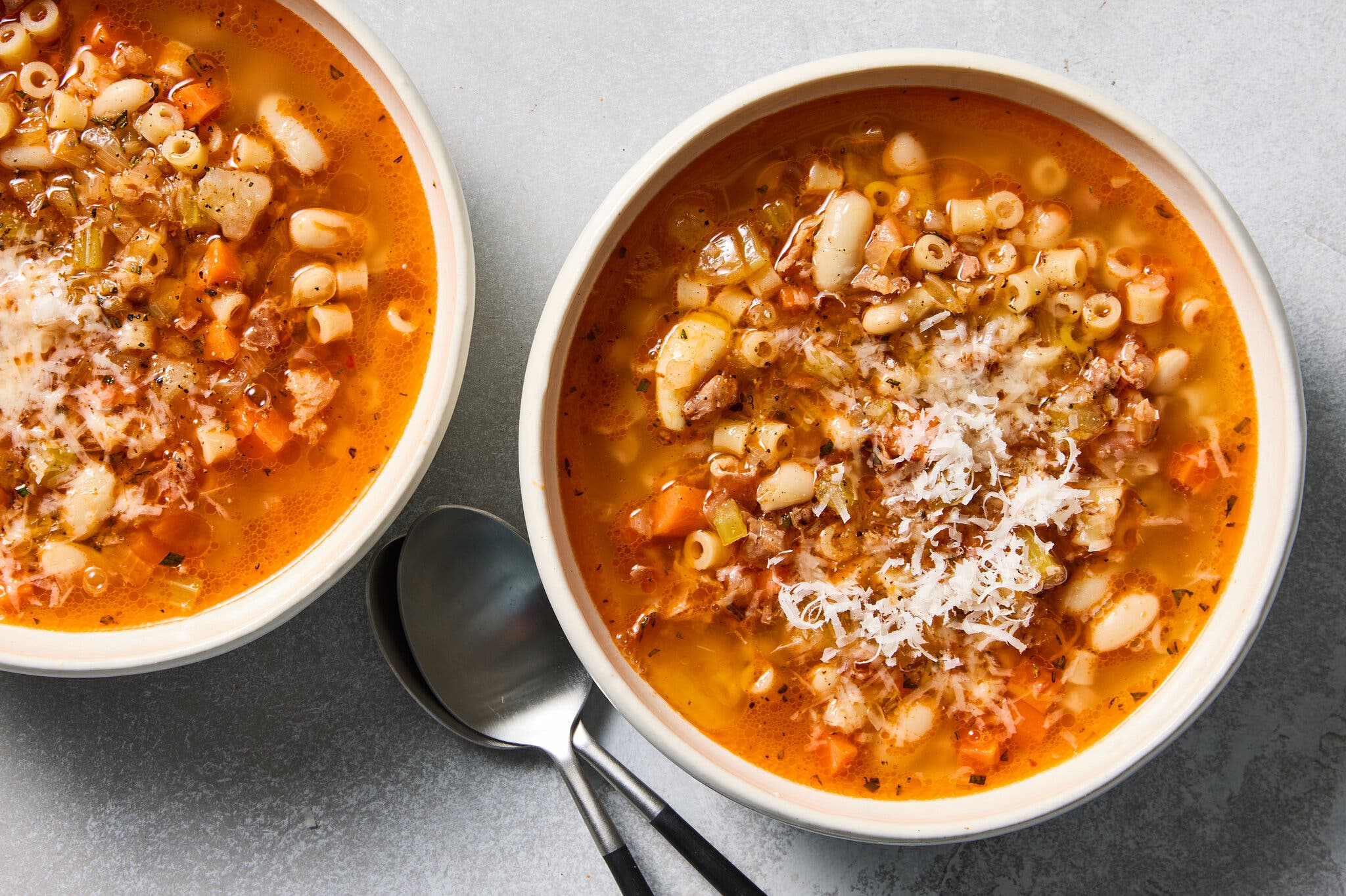 Ditalini pasta and white bean soup in a light broth, topped with a generous dusting of grated cheese.
