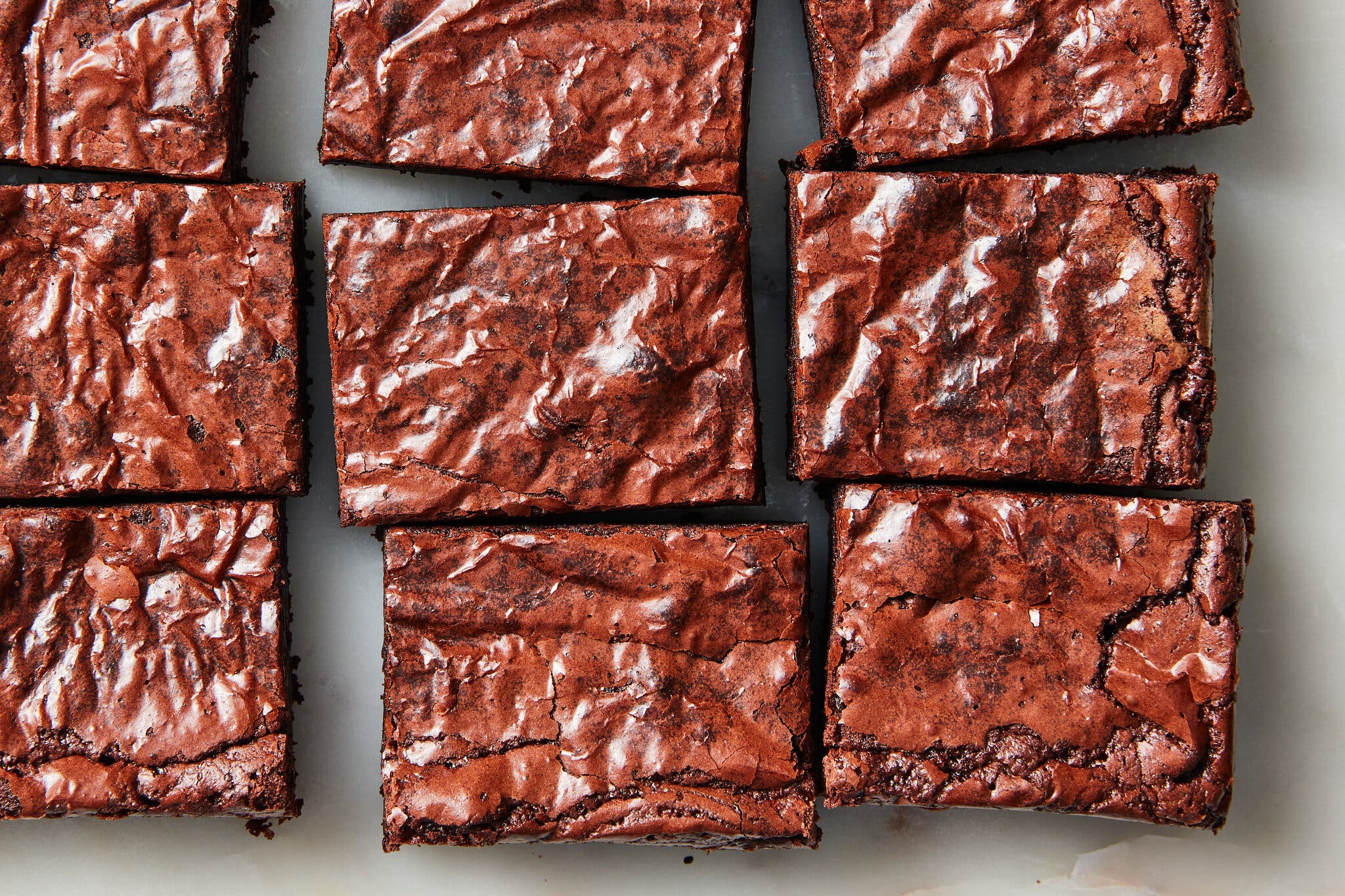 A close-up image of rows of brownies, with crackly tops. 